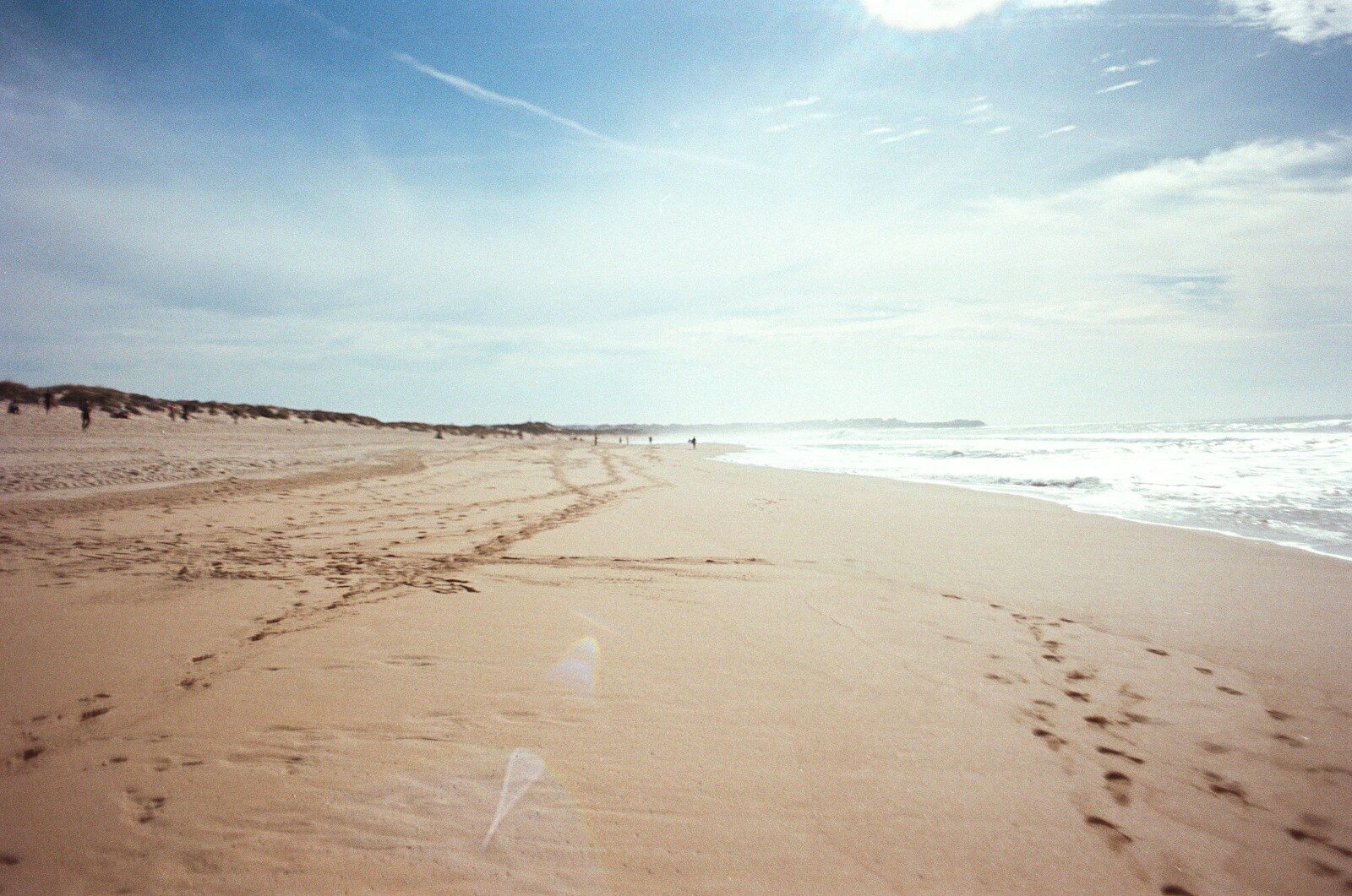 a sandy beach with waves crashing on it
